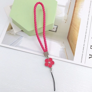 Macro shot of pink braided strap with a camellia flower pendant and rhinestone center