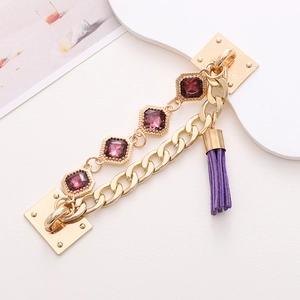 Detail of gold chain with purple gems, square mounts and purple tassel for DIY crafts