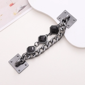 Detail of gunmetal chain link strap with faceted black resin stones and rivet mounts