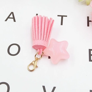 Detailed view of pink star pendant with suede tassel and golden lobster clasp