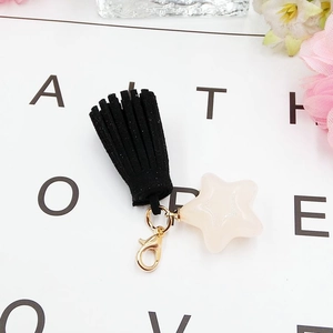 Fashionable keychain with black suede tassel and creamy white star pendant on gold lobster clasp