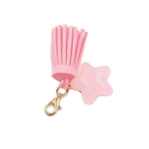Pink star resin charm with soft suede tassel and golden lobster clasp on white background
