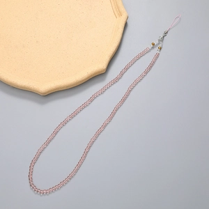 Macro detail of handmade pink beaded nylon lanyard with gold accents for mobile phones