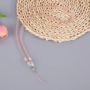 Pink handmade crystal bead nylon phone lanyard with silver lobster clasp on a woven mat