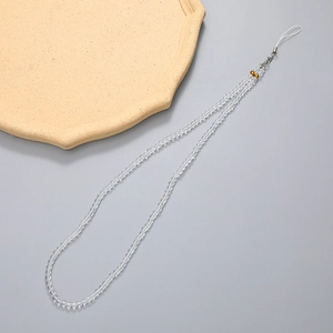 Macro detail of transparent beaded phone lanyard with silver clasp and gold bead accents