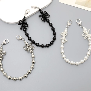 Beaded pearl bow phone charms in black, white, and silver with heart clasps