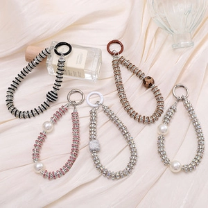 Close-up of five colorful beaded wristlet keychains with assorted charms and clips