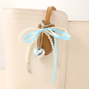 Porte-clés élégant avec perles, nœud en ruban et pendentif cœur sur sac en cuir