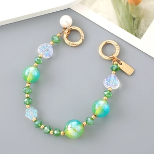 Macro shot of green crystal beads and iridescent pearls for mobile phone charm strap