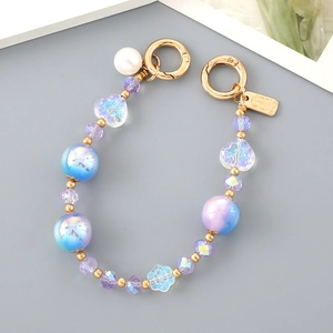 Detail of beaded phone strap with iridescent heart beads, blue flower, and golden lobster clasps