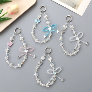 Eleganti ciondoli per borsa con farfalle di perle e cristalli su sfondo grigio chiaro