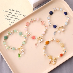 Beaded pearl bracelet with fishtail charm in pastel colors on an elegant tray