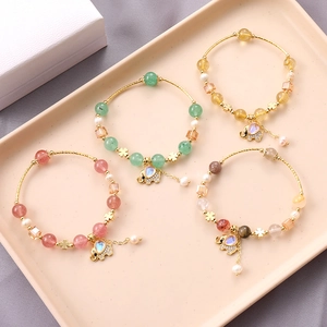 Beaded bracelets featuring gemstone elephant charms and gold clover accents for women