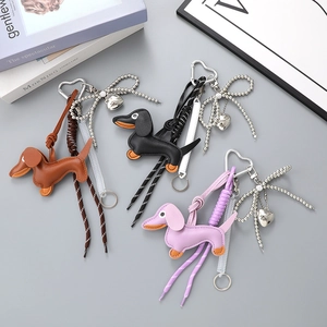 Dachshund leather keychains in brown, black, and pink with woven bow and heart clasp