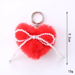 Détail du porte-clés cœur en peluche rouge de 9,5cm avec nœud en perles blanches
