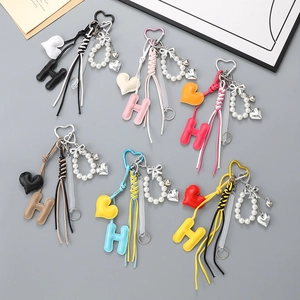 Set di ciondoli per borsa in pelle colorata con cuore, lettera H, perle e fiocco