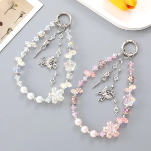 Detail of beaded floral bag charms featuring metallic butterfly and rose pendants