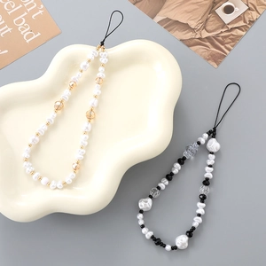 Detailed view of handmade beaded phone straps with imitation pearls and gold metal spacers