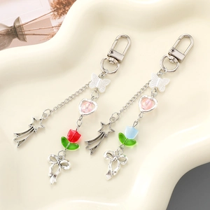 Detail of Y2K silver alloy keychains with acrylic butterflies, tulips, and star charms