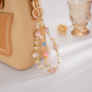 Detail of beaded bag charm with pink pearls, gold butterfly, and tiny floral accents