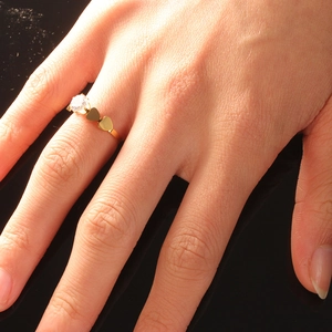 Polished gold stainless steel heart ring with sparkling round zircon on model finger