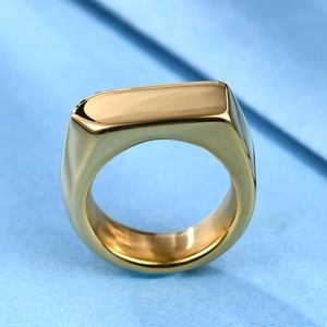 Macro shot of polished gold rectangle signet ring with mirror finish on blue background