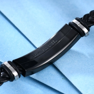Detalle de pulsera de cuero trenzado negro con grabado de acero inoxidable y anillos de metal