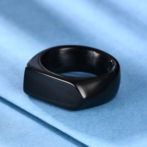 Macro close-up of a 9mm polished black stainless steel signet ring on blue fabric