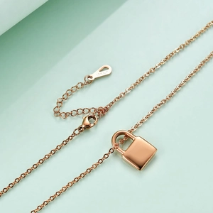 Vue macro du pendentif cadenas en or rose et gravure 18KGP sur la chaîne ajustable