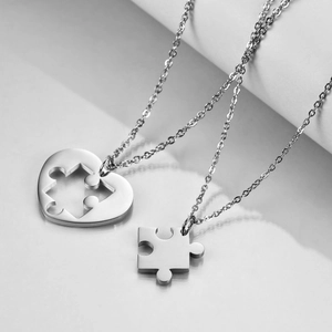 Close-up of interlocking heart and puzzle piece pendant set in polished stainless steel