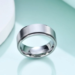 Gros plan d'une bague en acier inoxydable brossé de 8 mm avec rainure sur base menthe
