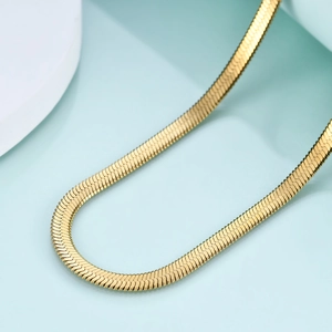 Makro-Detail einer 4mm polierten goldenen Schlangenkette mit reflektierender Metallstruktur