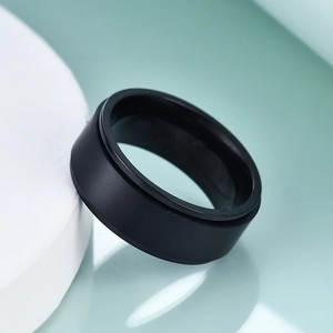 Gros plan d'une bague rotative de 8 mm en acier inoxydable noir mat sur un support minimaliste