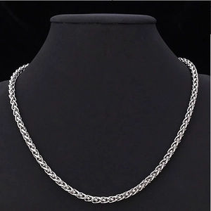 Collier maille épi en acier inoxydable argenté exposé sur un buste de présentation noir