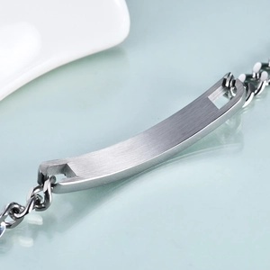 Macro shot of 7mm brushed silver stainless steel curved ID plate with chain details