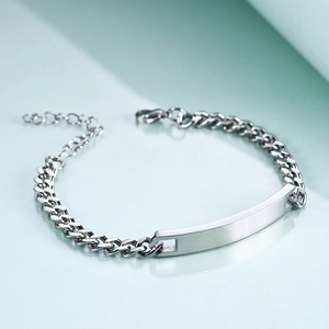 Detailed macro view of silver stainless steel curb chain bracelet with blank metal plate