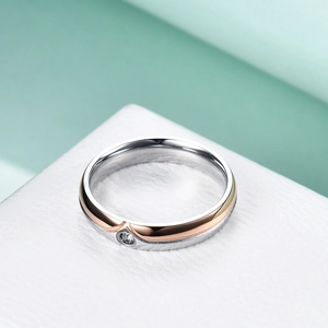 Macro shot of two-tone stainless steel ring with V-groove design and sparkling center stone