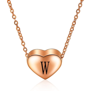 Detailopname van roségouden hart hanger met gegraveerde letter W en spiegelglans