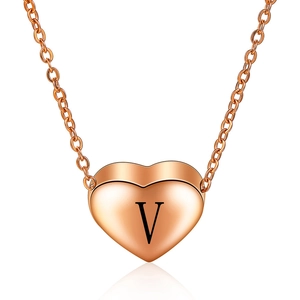 Detail van 3D roségouden hartvormige hanger met letter V op een schakelketting