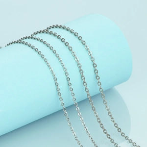 Detailed close-up of a silver stainless steel cable chain wrapped on a blue prop