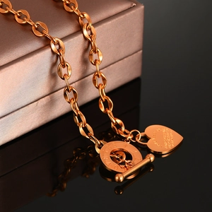 Dettaglio della collana OT oro rosa con ciondolo a cuore e incisione di versi biblici