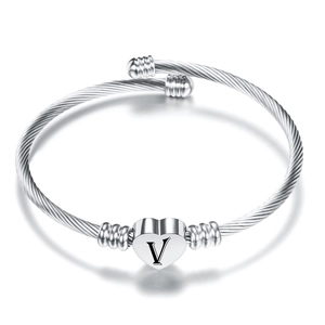 Dettaglio ravvicinato del bracciale in filo d'acciaio argento con cuore inciso della lettera V