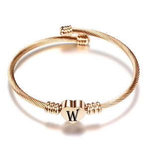 Detail van roségouden kabelarmband met hartvormige hanger en een zwart gegraveerde letter W