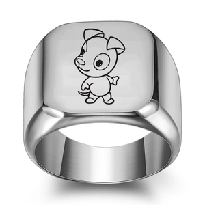 Détail macro d'une bague chevalière argentée avec motif de chien de dessin animé gravé