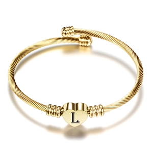 Detail van 18K gouden gedraaide kabelarmband met hartvormige hanger en gegraveerde letter L