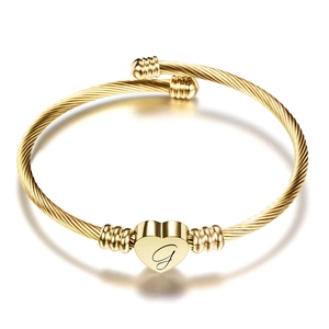 Golden twisted cable bracelet with a heart pendant featuring an engraved letter G