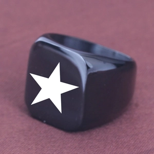 Close-up of a black stainless steel signet ring featuring a white pentagram star engraving