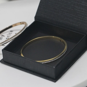 Detailed shot of a gold-plated minimalist bracelet with crystals in a black jewelry gift box
