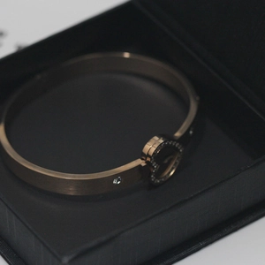 Detail of rose gold heart bracelet with pavé diamonds in a black textured jewelry box