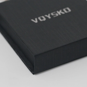 Close-up of black textured gift jewelry box with silver embossed logo for necklaces
